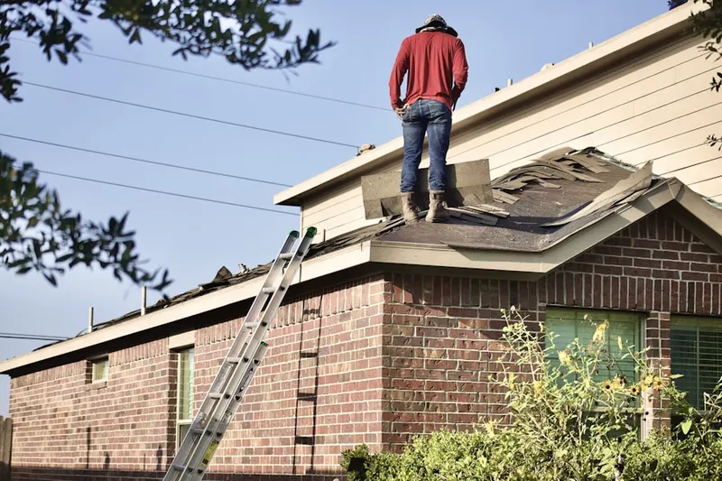 Professional roofer working on a residential roof in Hunt